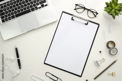 Home office desk workspace with silver notebook and office accessories on white background.