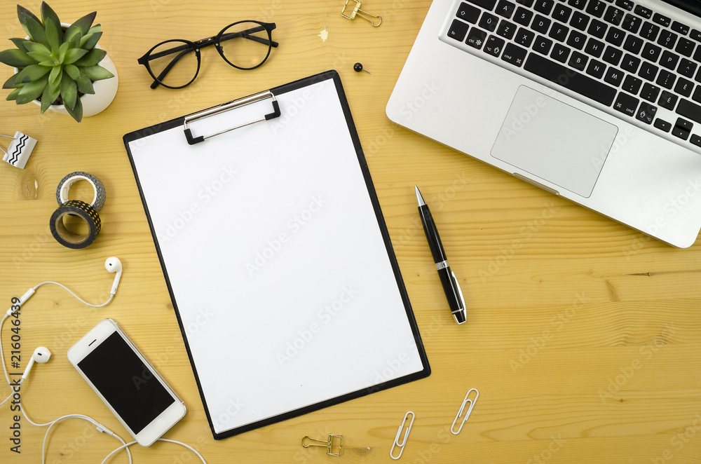 Clipboard mockup. Home office desk workspace with with silver notebook, smartphone and office accessories on wood desk background. Clipboard mockup. Home office desk workspace with with silver notebook, smartphone and office accessories on wood desk background.