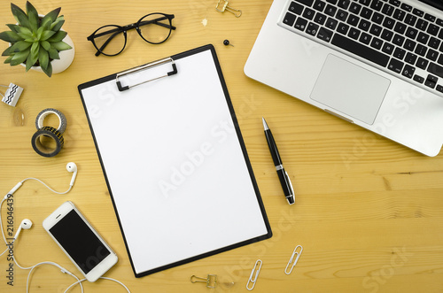 Clipboard mockup. Home office desk workspace with with silver notebook  smartphone and office accessories on wood desk background.