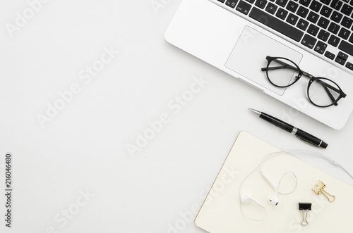 Mock up Office supplies on white desk work place with laptop  clips  glasses  notebook  pen and headphones. Top view with copy space  flatlay square mockup