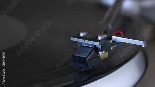 Turntable with vinyl LP record and tonearm moving off. photo