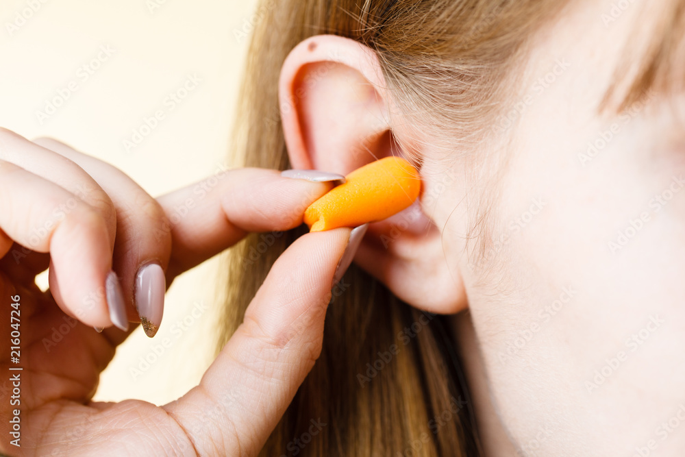 Woman putting earplugs