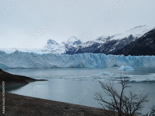 Glaciar azul con lago y montañas nevadas