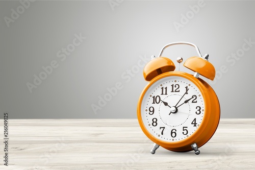 Orange retro alarm clock on wooden table