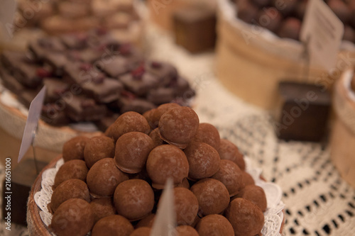 Asorted chocolate truffles and pralines. Chocolate and coconut candies on the counter in the confectionery store photo