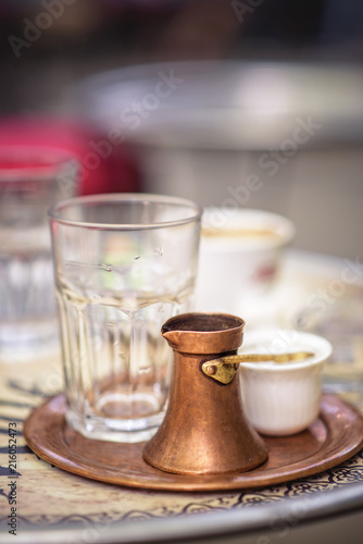 Sarajevo, capital of Bosnia. Traditional handcrafted copper plated coffee filled with traditional foam Bosnian coffee served in an ornament Sarajevo set