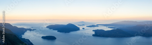 Panoramic landscape view of Howe Sound during a vibrant summer sunrise. Taken from the top of Brunswick Mountain, North of Vancouver, BC, Canada.