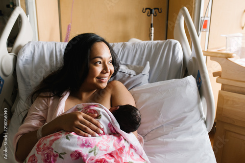 Woman feeding newborn daughter in hospital