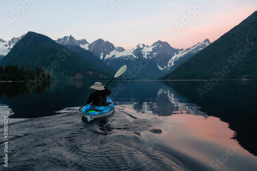 Adventurous man kayaking in the water surrounded by the Beautiful Canadian Mountain Landscape. Taken in Jones Lake, near Hope, East of Vancouver, BC, Canada. © edb3_16