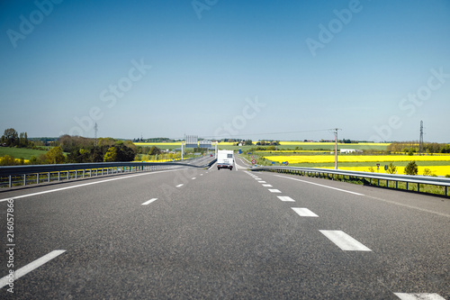 Camper RV van driving fast on French highway toward holiday destination and clear blue sky