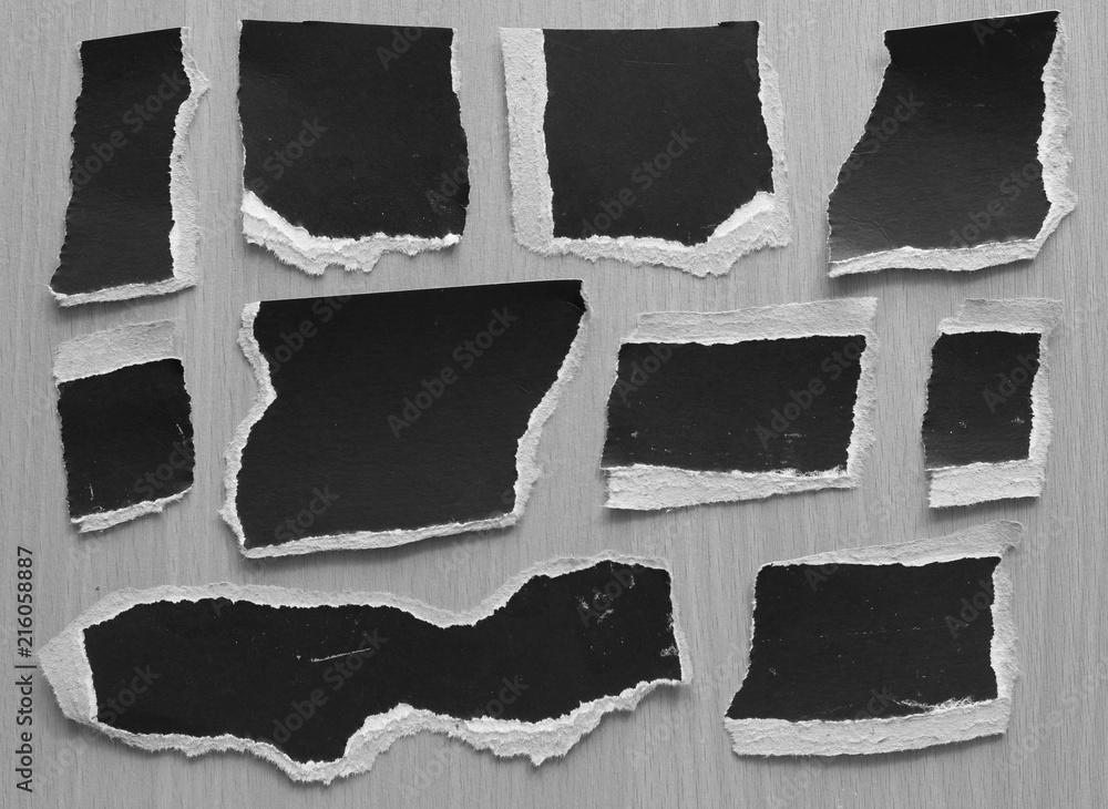 black torn paper texture on wood background, copy space.