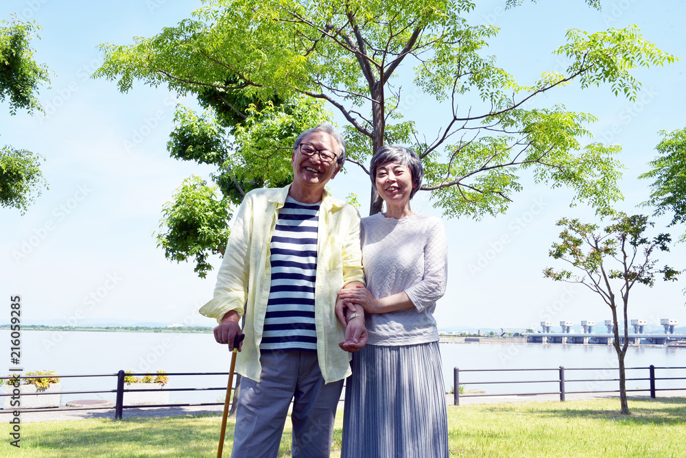公園で散歩する笑顔のシニア夫婦 公園で散歩する笑顔のシニア夫婦