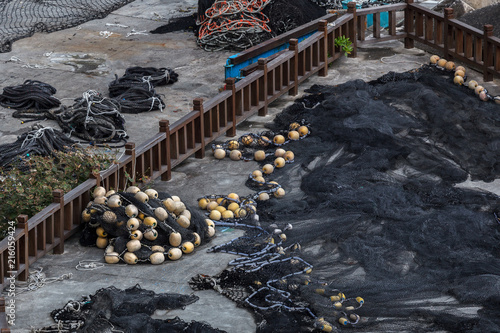 Stockpile of black fishing net and miscellaneous buoys near a fishing harbor in Taiwan. Example of overfishing, depleting world resources. Excessive fish farming