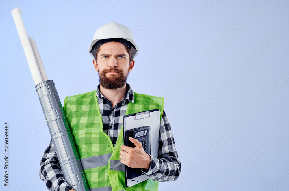 serious builder in a helmet with drawings serious builder in a helmet with drawings