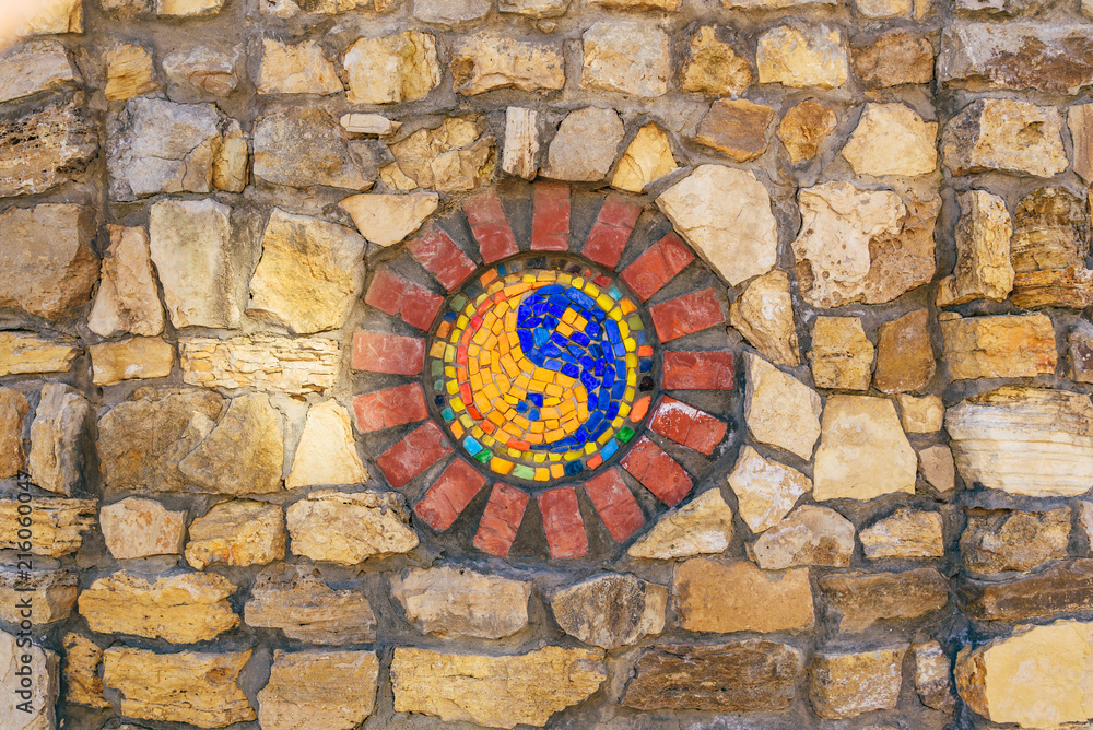 Mosaic symbol of Yin and yang on stone wall. Mosaic symbol of Yin and yang on stone wall.