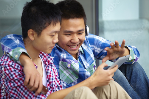 two boy sitting outside with mobile photo