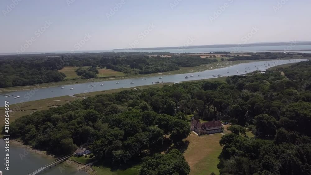Drone aerial view pan left to right over the Beaulieu River South England UK with the Isle of Wight in background. Day time sunny wide shot. Drone aerial view pan left to right over the Beaulieu River South England UK with the Isle of Wight in background. Day time sunny wide shot.
