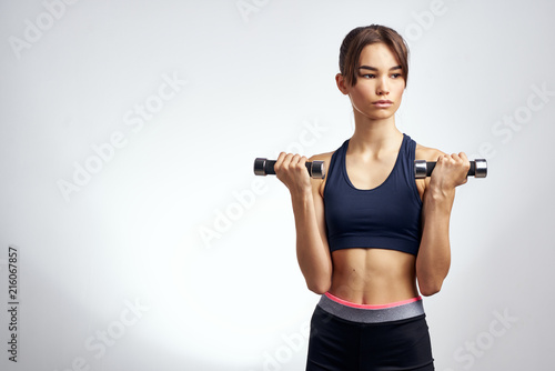 sport fitness woman with dumbbells keeps fit body