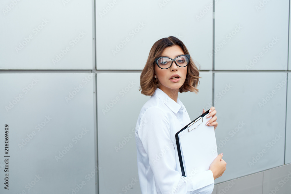business woman with documents on the background of the building on the street business woman with documents on the background of the building on the street