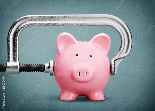 Pink piggy bank and clamp on background