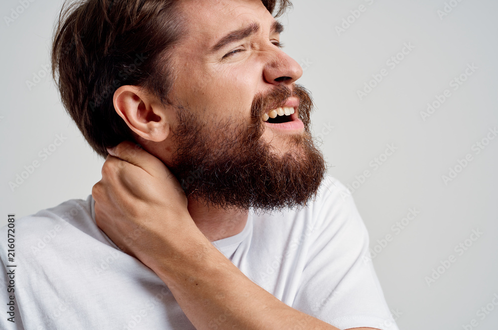 Obraz premium man with a beard holding his neck pain