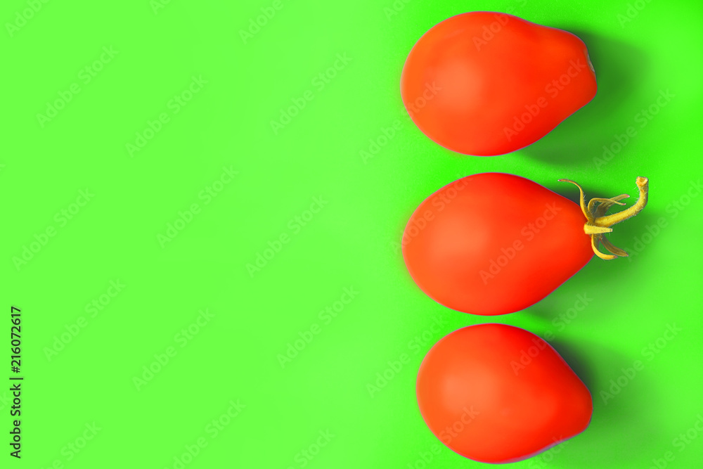 Obraz premium oval fruits of tomatoes on a green background