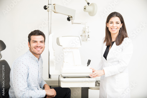 Cheerful doctor and patient at eye clinic smiling