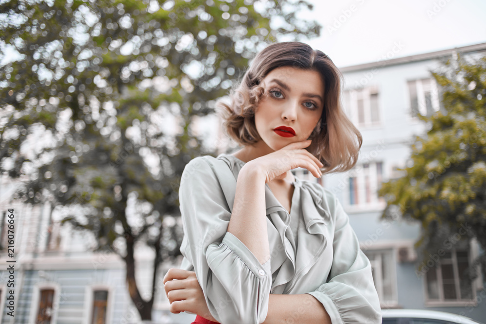 attractive woman is walking in the park, building in the background