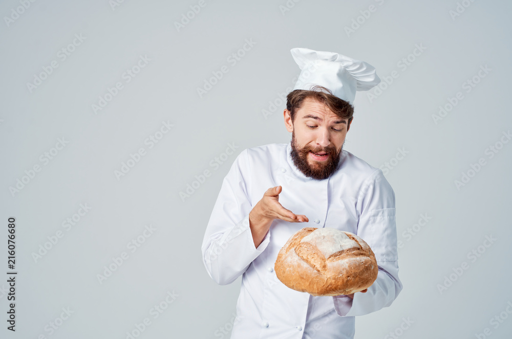a chef wearing a headdress shows his hand on a loaf of bread a chef wearing a headdress shows his hand on a loaf of bread