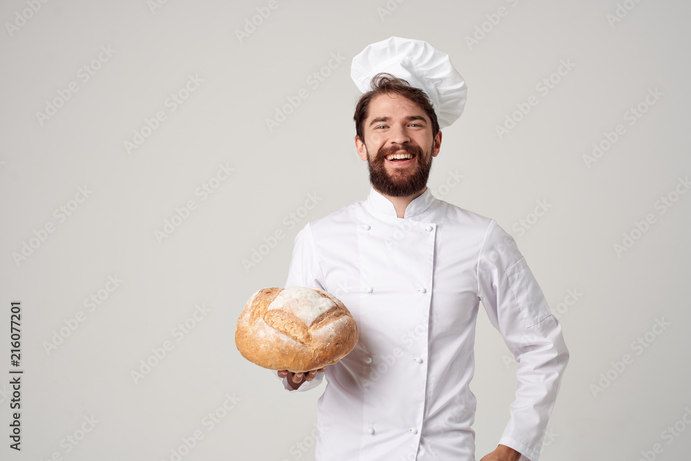 happy cook in a headdress holds a loaf of bread in his hand happy cook in a headdress holds a loaf of bread in his hand