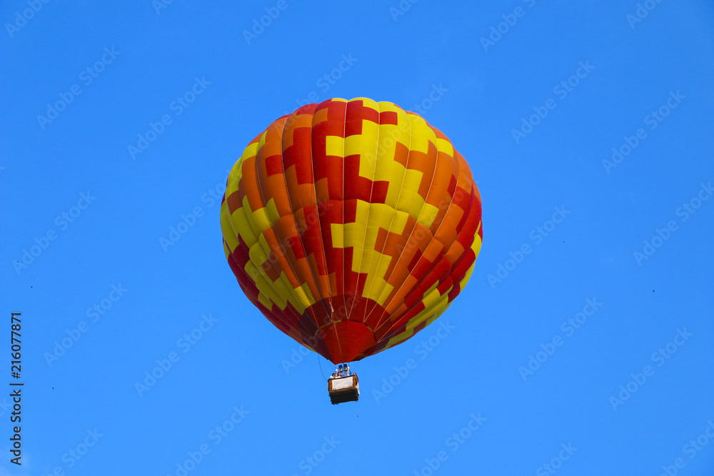 Obraz premium colorful hot air balloon against blue sky. hot air balloon is flying in white clouds. beautiful flying on hot air balloon