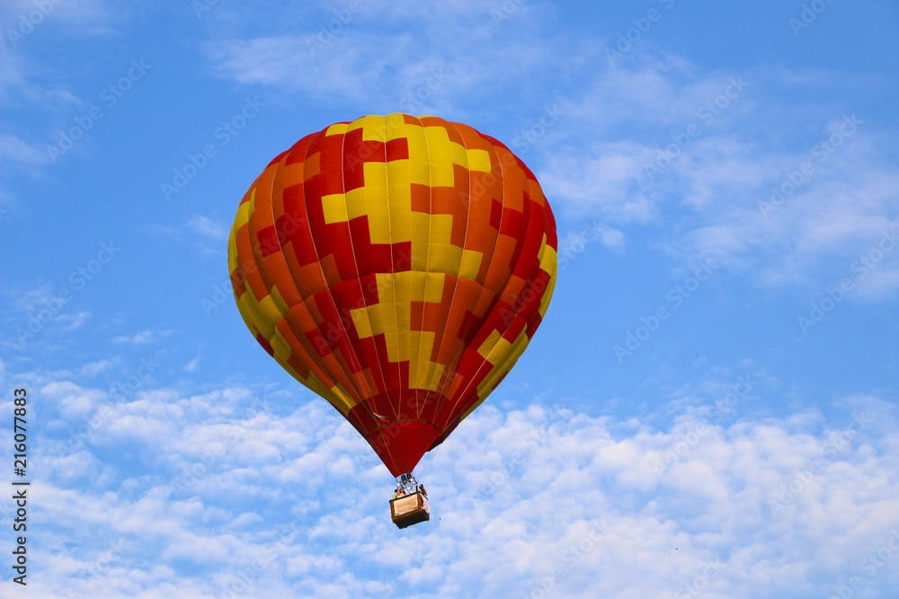 Obraz premium colorful hot air balloon against blue sky. hot air balloon is flying in white clouds. beautiful flying on hot air balloon