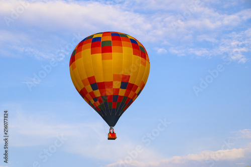colorful hot air balloon against blue sky. hot air balloon is flying in white clouds. beautiful flying on hot air balloon © Оксана Скиданова