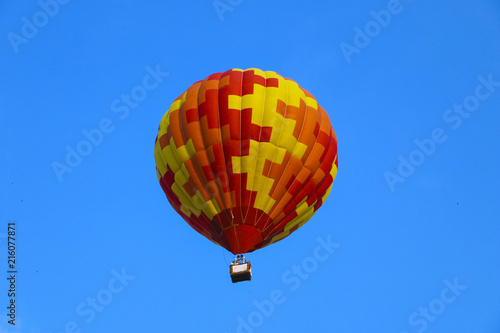 colorful hot air balloon against blue sky. hot air balloon is flying in white clouds. beautiful flying on hot air balloon