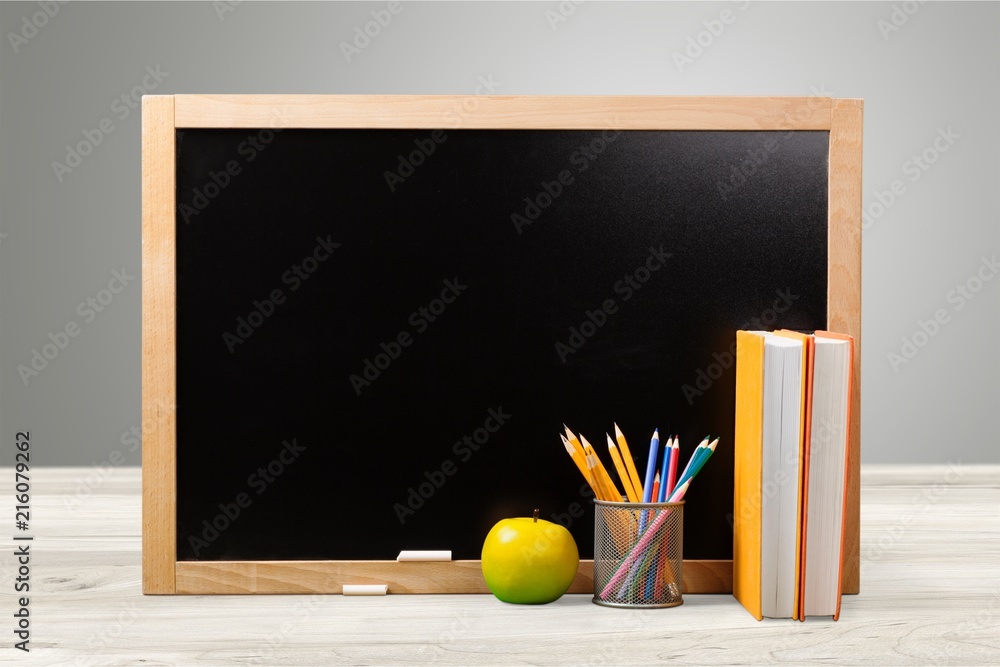 Colorful school supplies on blackboard background