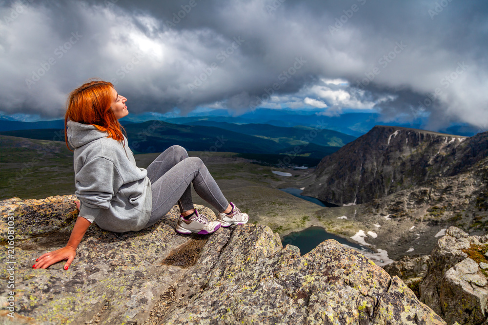 Naklejka premium Woman hiker enjoy the view at sunset mountain peak cliff. Stylish woman hiking. Travel Lifestyle and survival concept rear view.