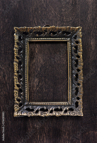Vintage bronze frame on a wooden background, top view