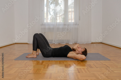 Woman working out at home relaxing on a mat