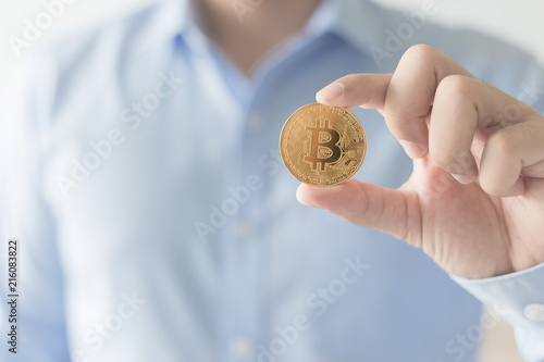 Selective focus businessman  holding a golden bitcoin.