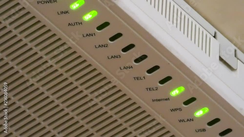 Green LED lights flashing on router. Internet and local network connection. Electronic device closeup view.