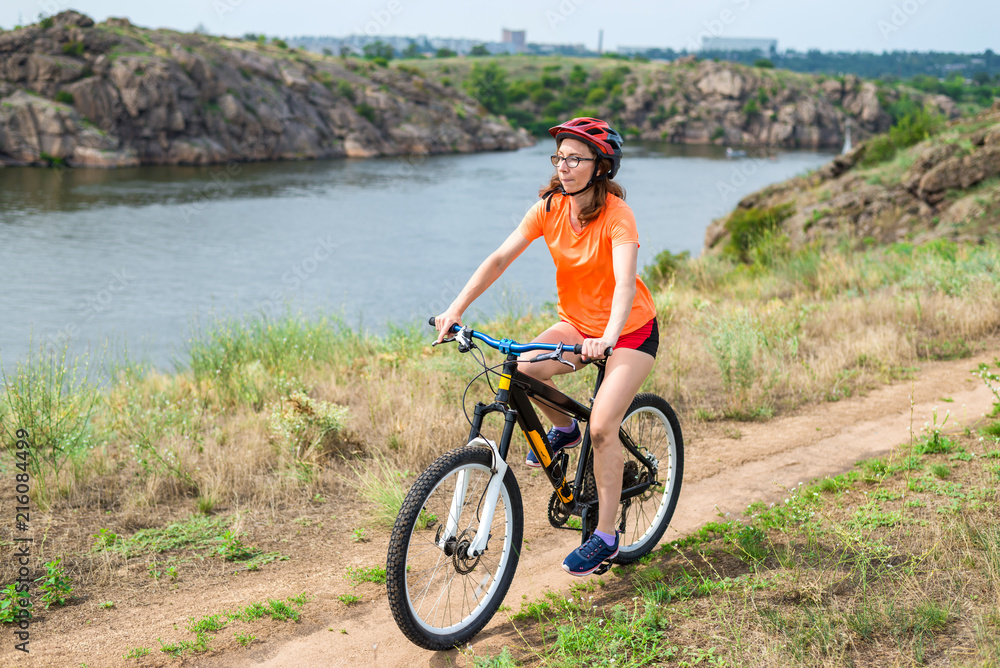 Fototapeta premium Young woman riding a mountain bike, an active lifestyle.