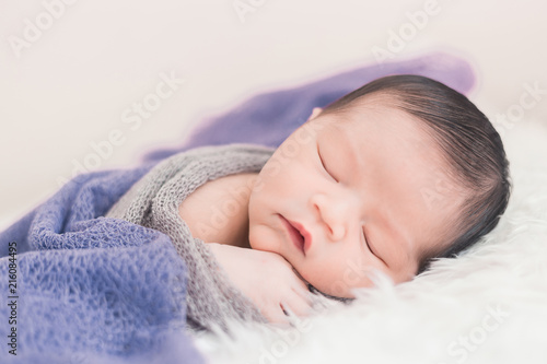 New born baby lying on a soft blanket. Cute  new born baby in natural motion.