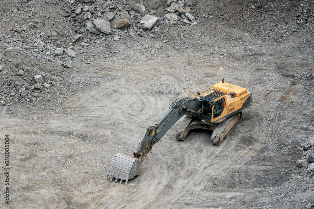 Mining in the granite quarry. Working mining machine - digger. Mining industry.