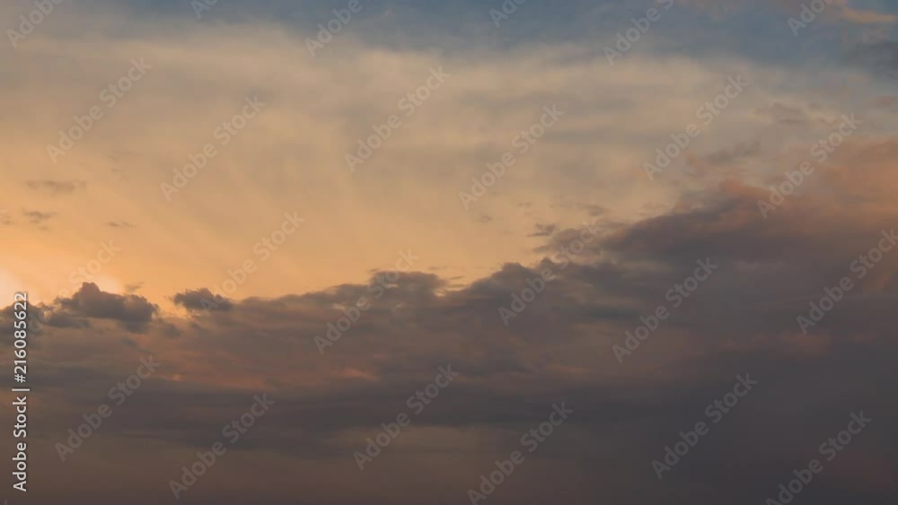 Dark clouds against an orange sunset-filled sky. Dark clouds against an orange sunset-filled sky.