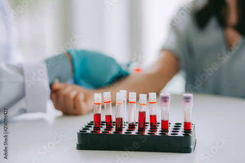  Blood sample Test tube , blurred background  : Hand of nurse, doctor or Medical technologist in blue gloves taking blood sample from a patient in the hospital.