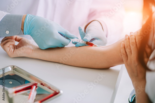 Close up Hand of nurse, doctor or Medical technologist in blue gloves taking blood sample from a patient in the hospital.
