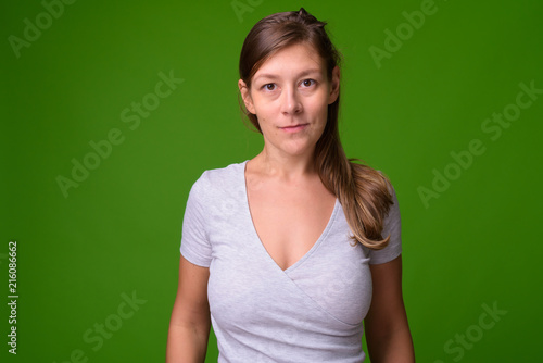 Young beautiful woman against green background