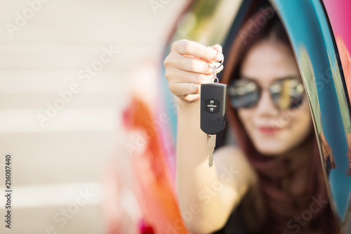 Beautiful asian woman with car key enjoying life in the red car.
