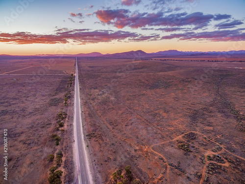 Straight rural road disappearing in the distance at dusk. Flinders Ranges, South Australia © Greg Brave