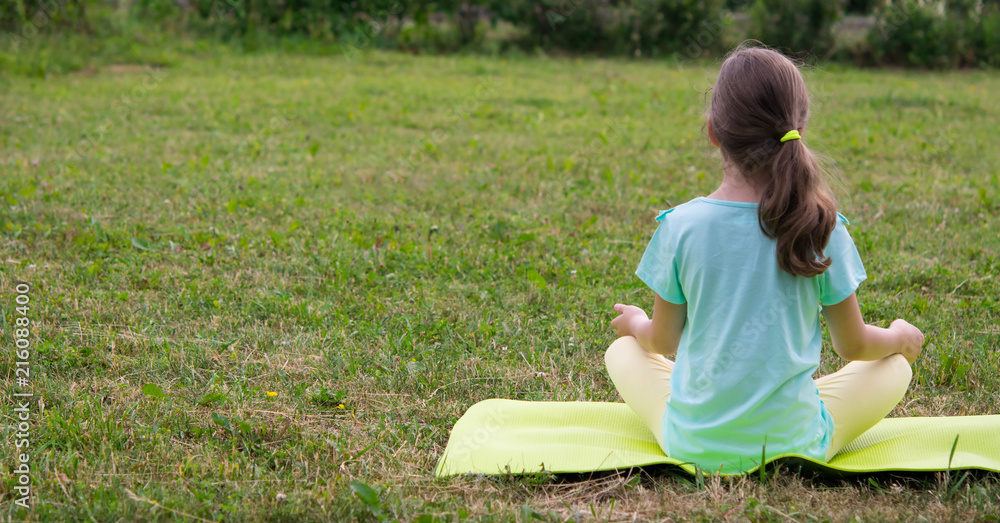girl outdoors on the grass, alone, doing yoga.